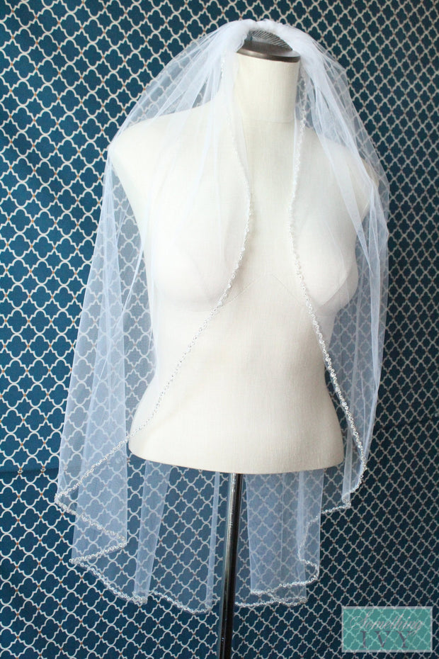 https://somethingivy.com/cdn/shop/products/36-inch-swarovski-crystals-and-bugle-beads-on-silver-edge-beaded-cut-edge-veil-4_a5e84ae8-399d-4fc9-8ffe-70a20e7607b8_620x.jpg?v=1591501057